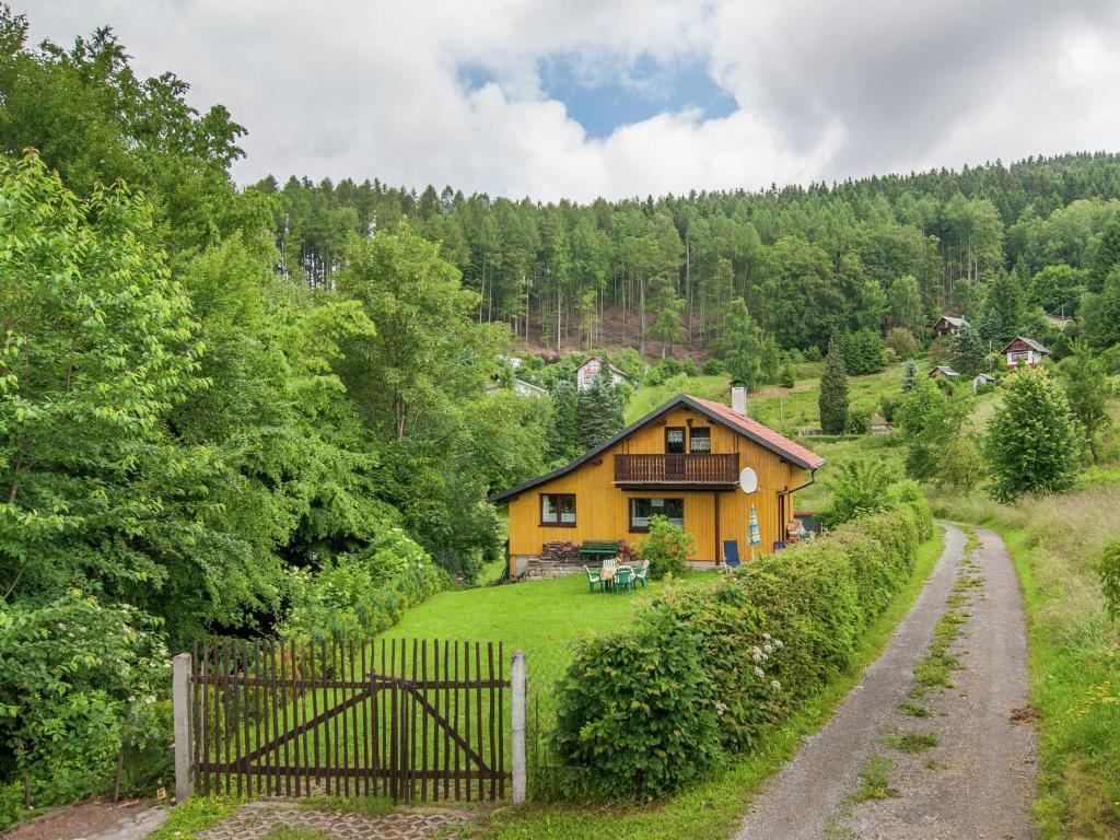 ein gelbes Haus auf einem Hügel mit einem Zaun in der Unterkunft Holiday home near the ski area in Kurort Steinbach-Hallenberg