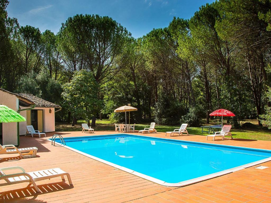 una piscina con sillas y sombrillas en una terraza de madera en Belvilla by OYO Holiday Home with Pool, en Canneto