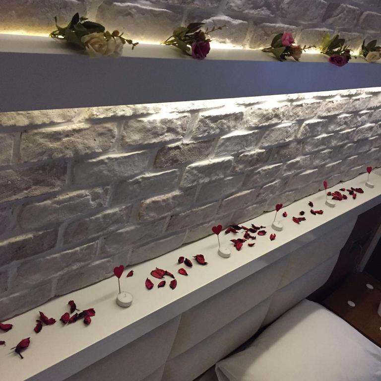 ein weißer Tisch mit roten Rosen in Weingläsern in der Unterkunft Aripsas Hotel in Giresun