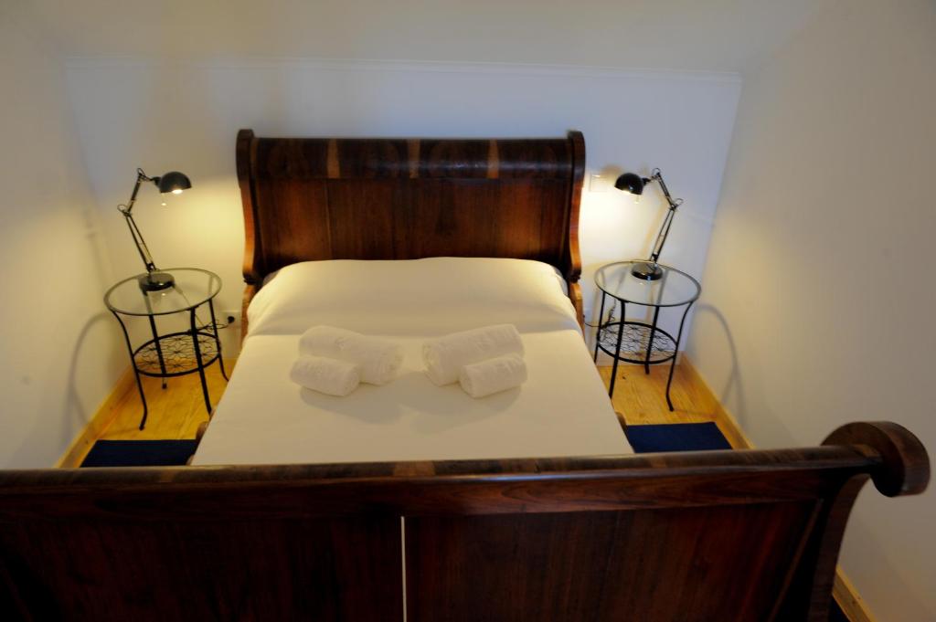 a bed with two towels on it with two lamps at Casa das Rendufas- Turismo Rural com Figos in Rendufas da Estrada