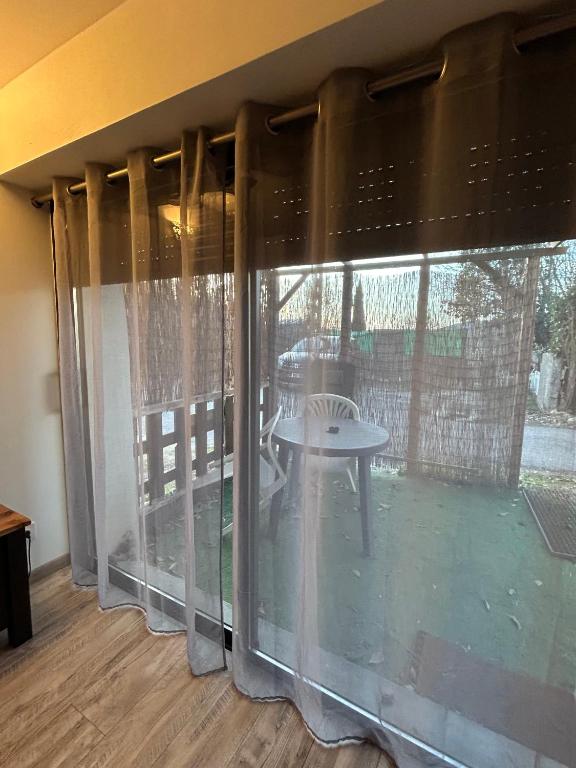 a room with a large window with a table outside at Studio au calme les hirondelles in Les Mées