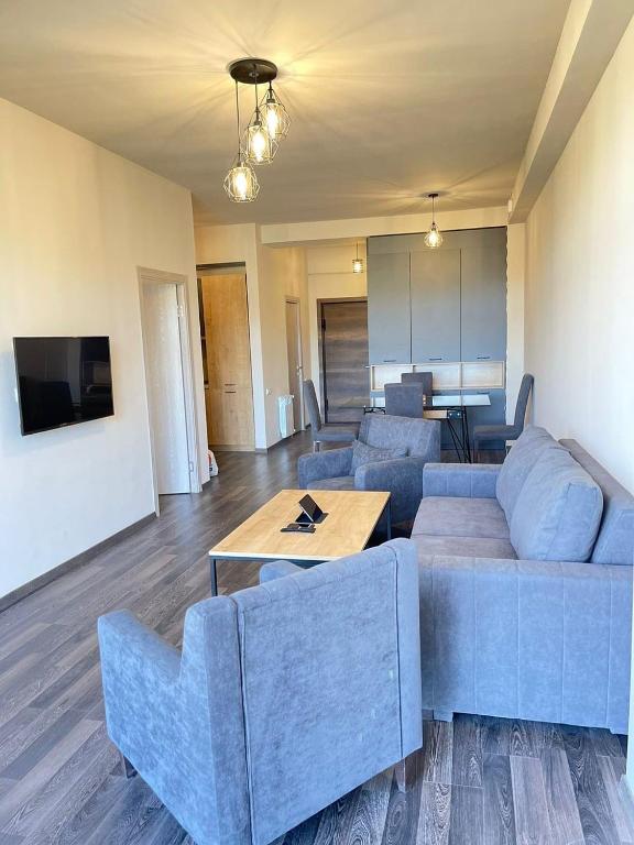 a living room with a blue couch and a table at Tsaghkadzor View Апартамент с видом на горы in Tsaghkadzor