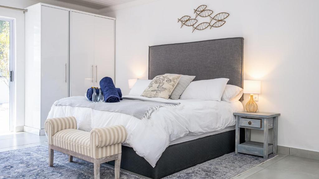 a bedroom with a large bed and a chair at Huis Marais in Herolds Bay
