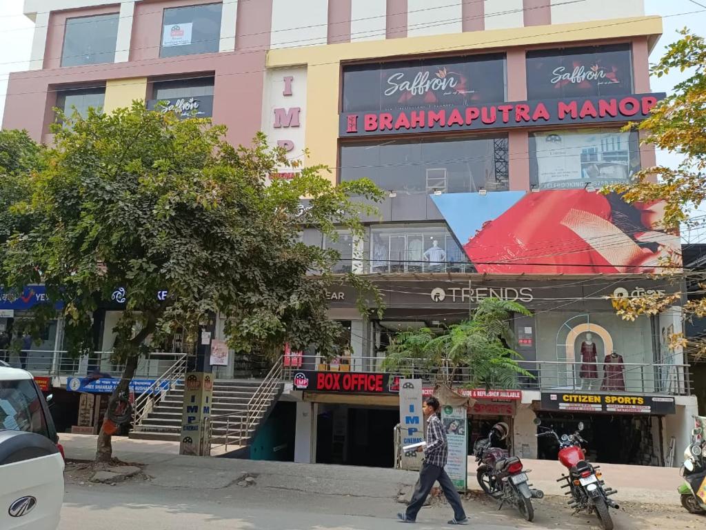 a man walking down a street in front of a building at Brahmaputra Manor in Tezpur