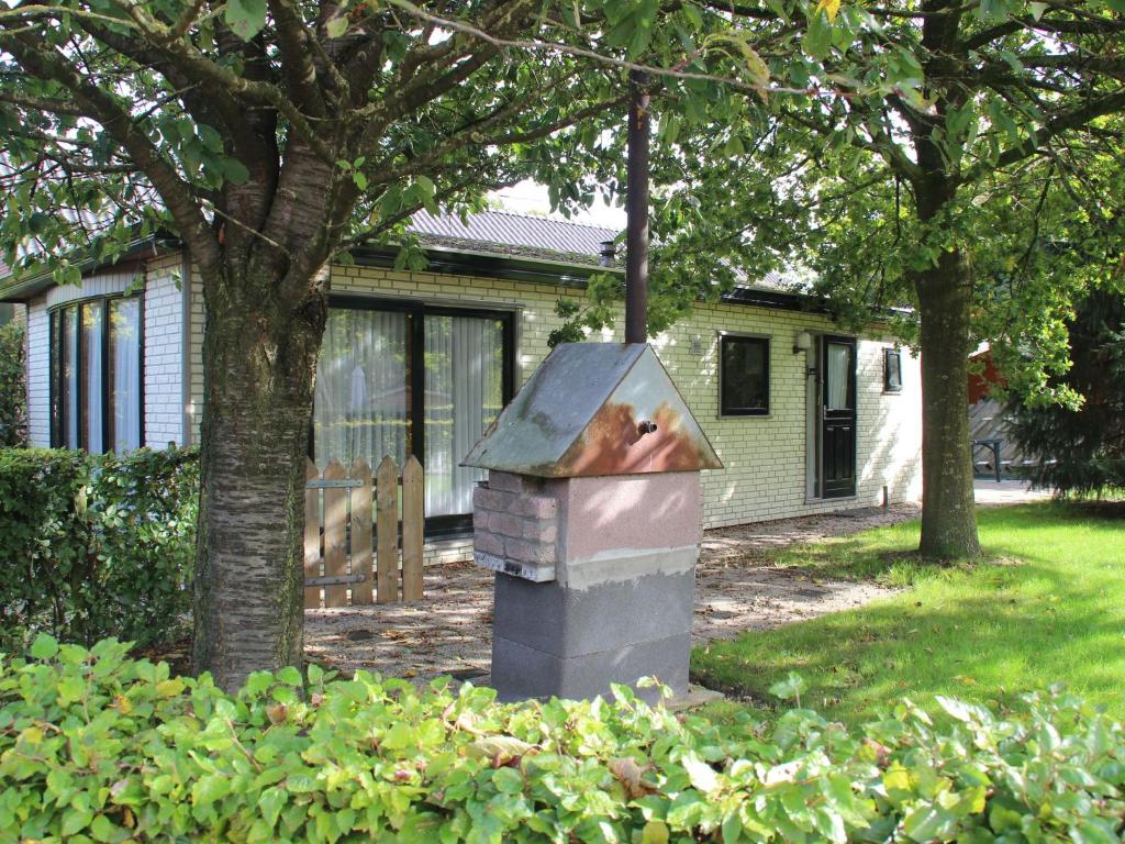 une poubelle peut s'asseoir devant une maison dans l'établissement Quaint Chalet in Uden with Terrace, à Uden