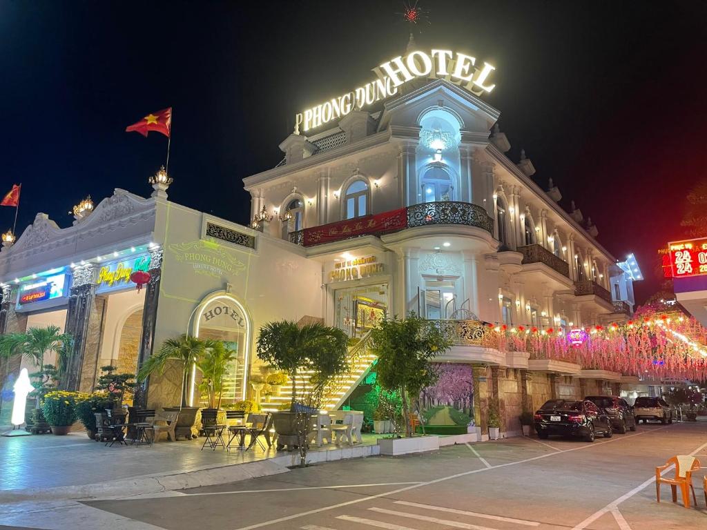 a large white building with a sign on it at night at Phong Dung Beach Hotel Phan Ri Cua in Tuy Phong