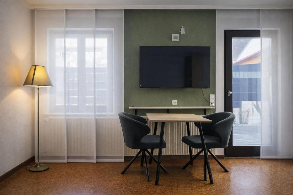 a room with a table and chairs and a television at SK Ferienapartments Kappelrodeck in Kappelrodeck