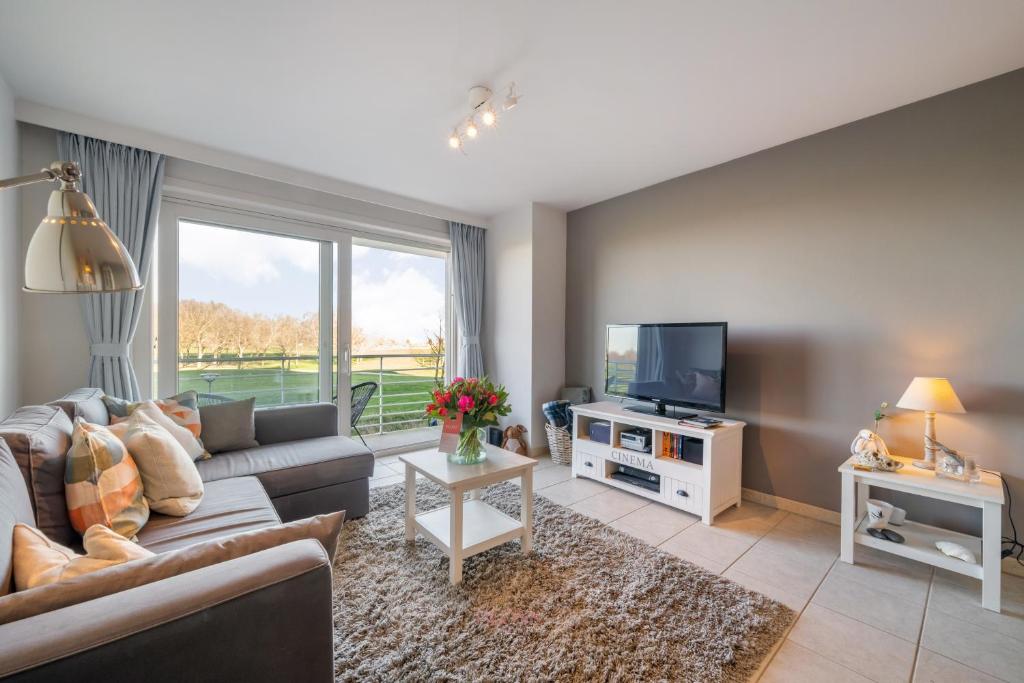 a living room with a couch and a tv at Port Albert by BLOSS in Nieuwpoort