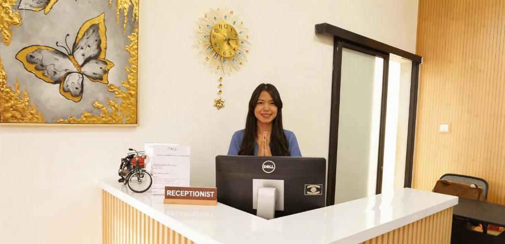 a woman sitting at a desk with a computer at Bale Cakra in Ngemplak