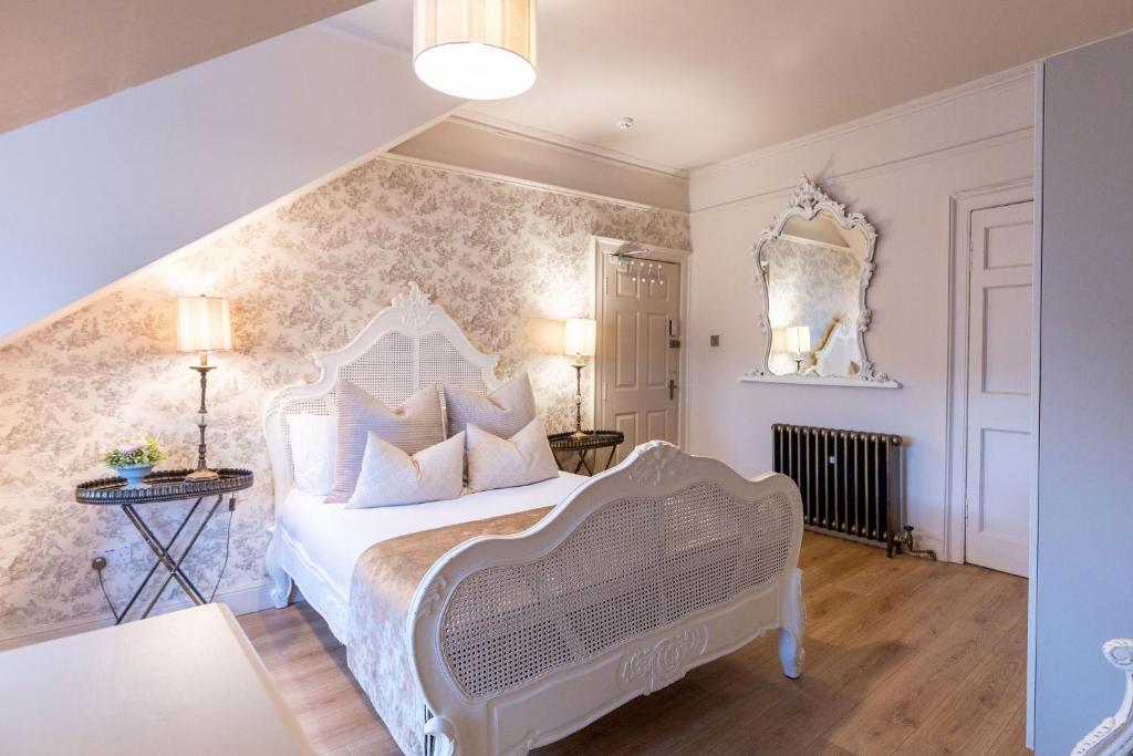 a bedroom with a white bed with white pillows at 38 Bide Collective in Edinburgh