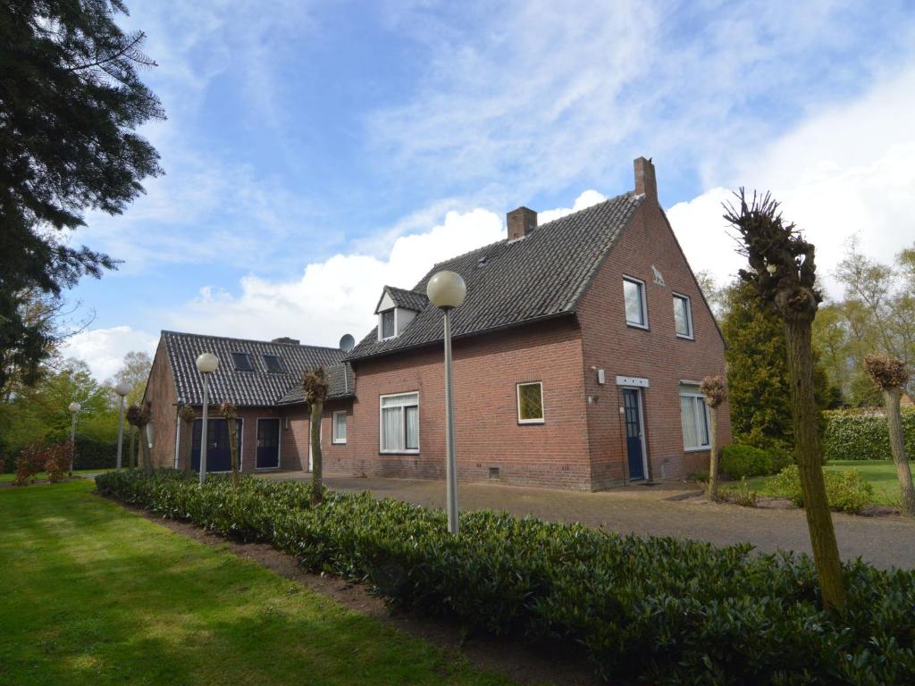 a large brick house with a driveway at Lovely holiday home with lots of privacy in Valkenswaard