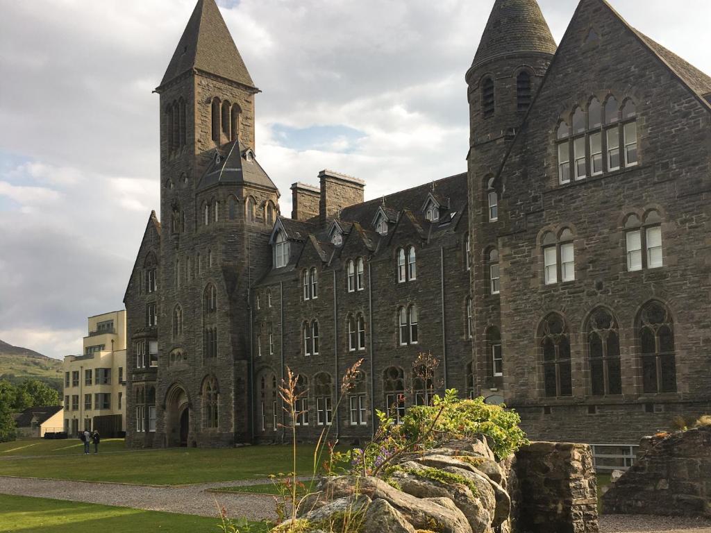 a large stone building with a clock tower at Moat House 6 - Ukc4889 in Fort Augustus