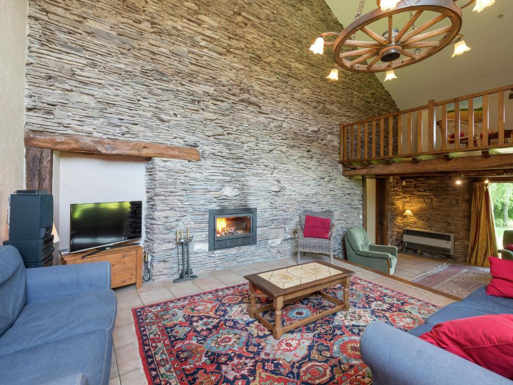 a living room with a fireplace and a tv at Quaint Cottage In Jevign with Terrace in Lierneux