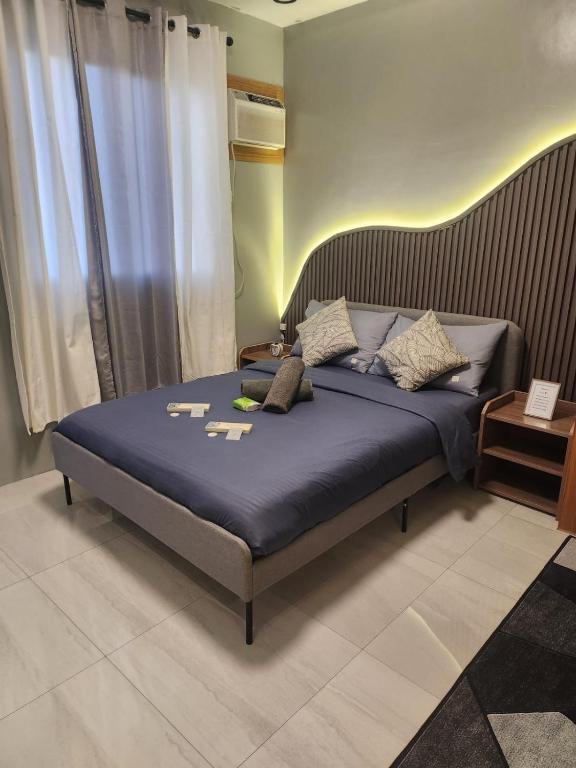 a bedroom with a large bed with blue sheets at Ohhlala Cozy Corner at Royal Oceancrest Mactan in Mactan Island