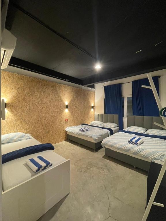 a room with three beds with blue towels on them at MAXi MaMa Room in Bangkok