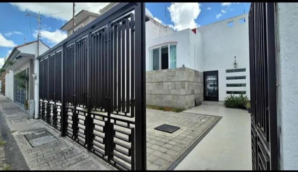 two views of a house with a black fence at Alma Xoloitzcuintle in Hércules