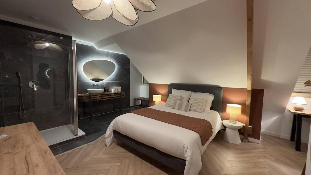 a bedroom with a large bed and a bathroom at La Tour en Seine in Les Authieux-sur-le-Port-Saint-Ouen