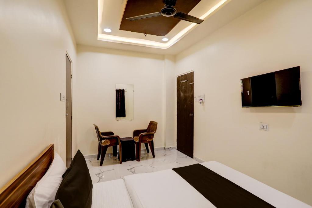 a bedroom with a bed and a table and chairs at Hotel O highway blues in Nagpur