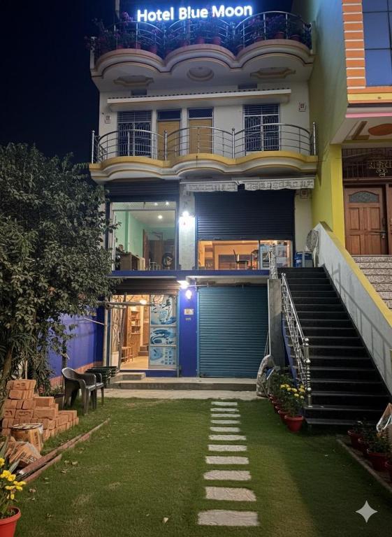 a house with a blue door and a lawn in front at Hotel Blue Mooon in Rājgīr