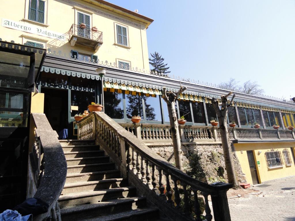 un bâtiment avec des escaliers en face d'un bâtiment dans l'établissement Hotel Valganna - Tre Risotti, à Valganna