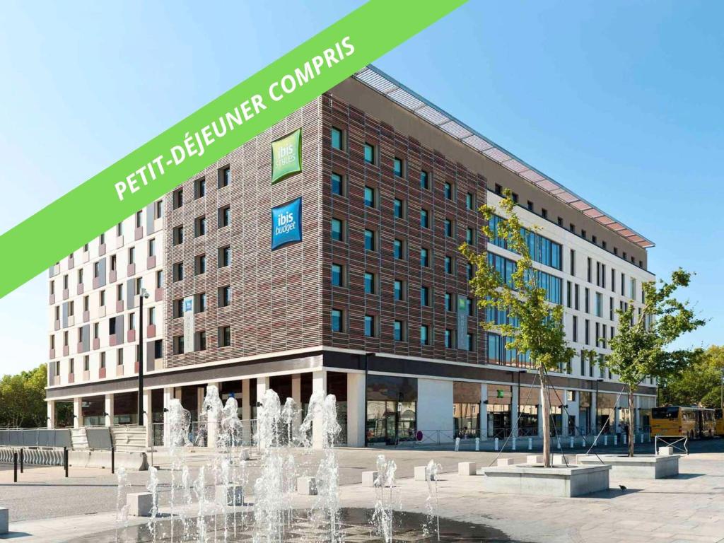 a building with a fountain in front of it at ibis Styles Nimes Gare Centre in Nîmes