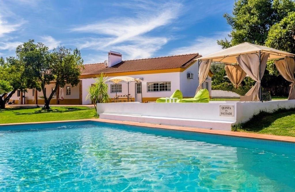 a swimming pool in front of a house at Quinta da Saudade in Ponte de Sor