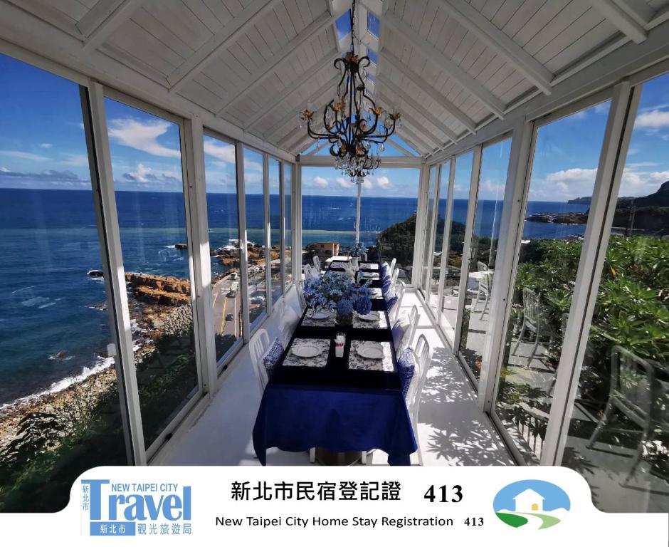 a dining room with a view of the ocean at Ample Villa 小希臘 in Ruifang