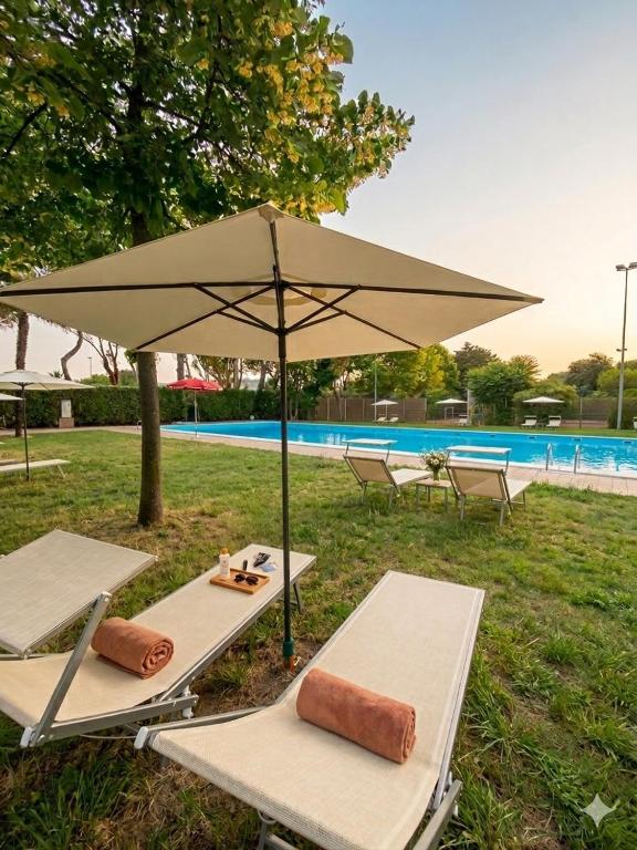 a table with an umbrella next to a pool at VILLETTA 8 - Premium Villas in Giulianova