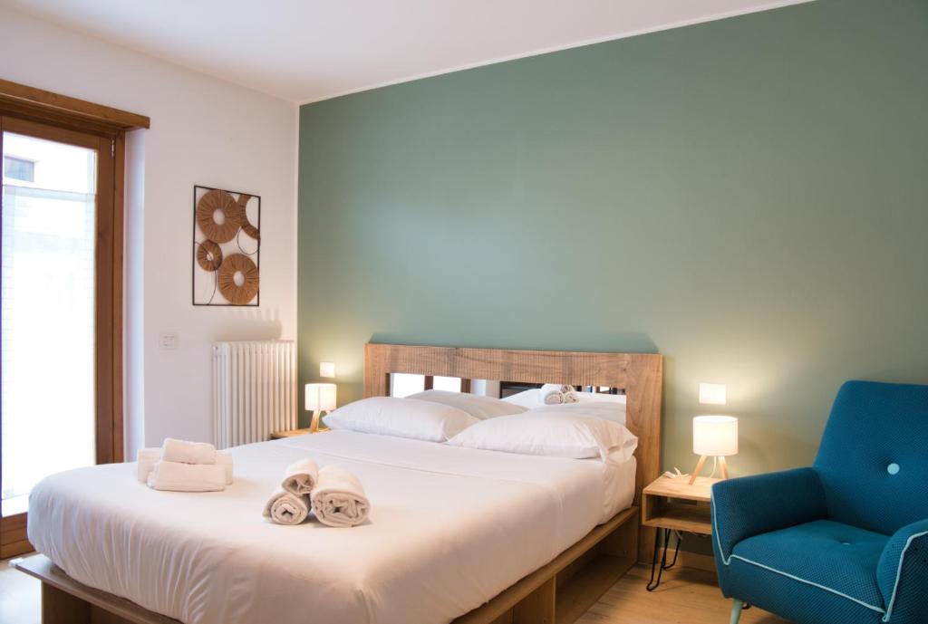 a bedroom with a bed and a blue chair at NNHouse: large terrace and marvelous view in Cassina Valsassina