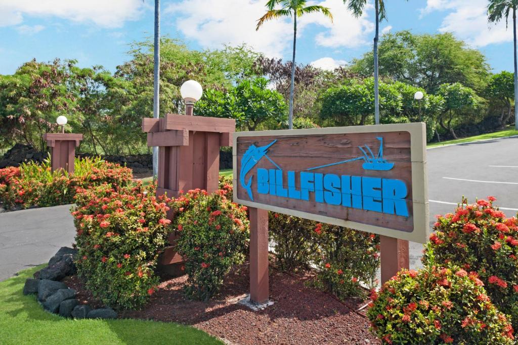 a sign in a garden with flowers at The Kona Billfisher in Kailua-Kona