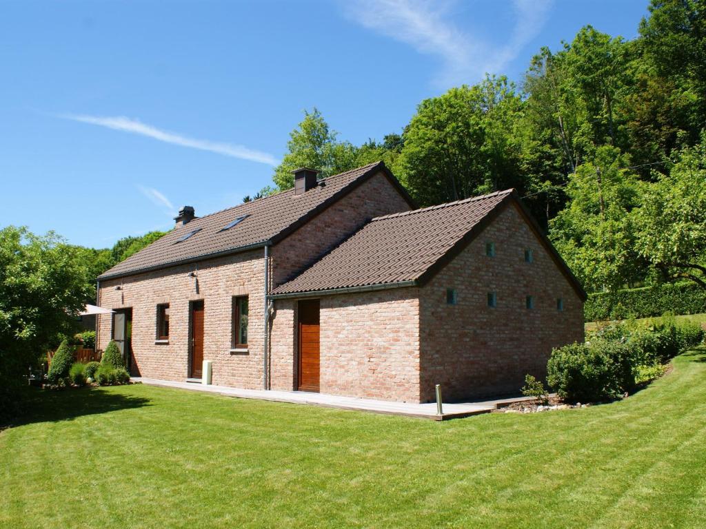 a brick house with a large lawn in front of it at Modern Holiday Home in Stavelot with Fireplace in Stavelot
