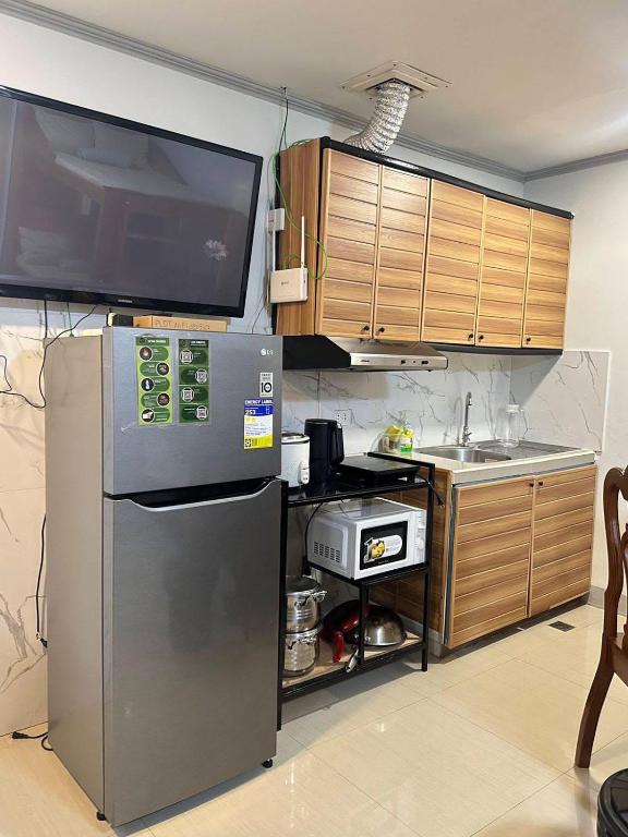 a kitchen with a stainless steel refrigerator and a sink at Your Quiet Home with Unbeatable location in Baguio