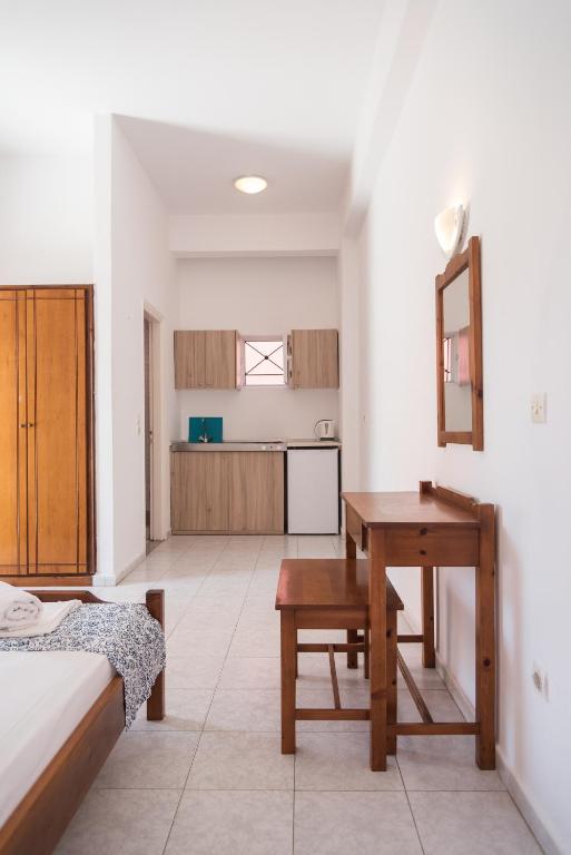 a bedroom with a desk and a bed and a kitchen at Fardini Seaside Hotel in Kavos