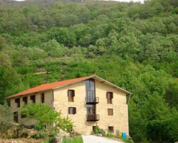 a building with a balcony on top of a hill at Albergue Aurora Boreal in Casas del Monte