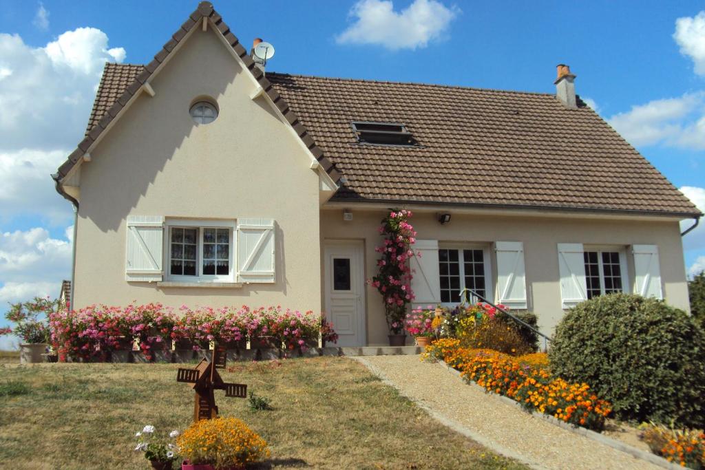 a small house with flowers in the front yard at le moulin à vent in Céré-la-Ronde