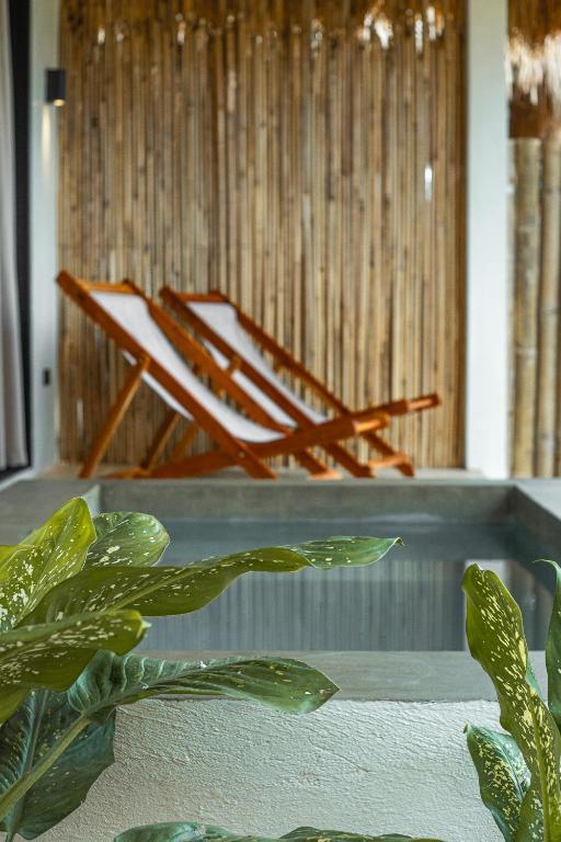 a chair sitting next to a table with a plant at Siroco Villas - Romantic Privet Pool Escape in Tagibo