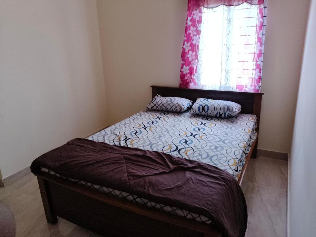 a small bed in a bedroom with a window at Kalpatharu Sprit Boarding and Lodging in Sivaganga
