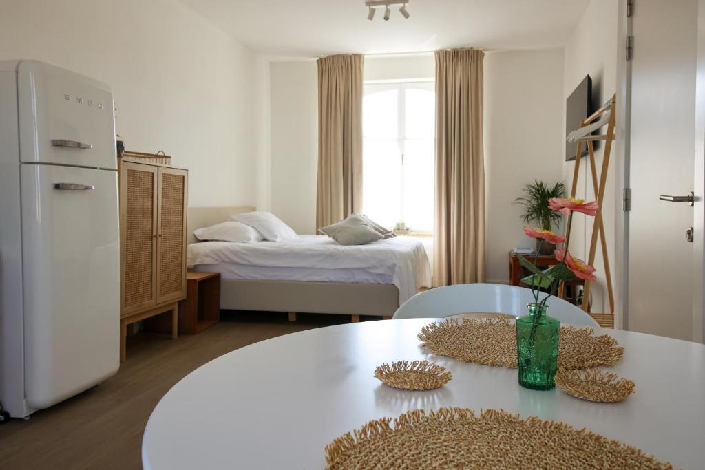 a living room with a table and a bed at Suite kaai 24 in Nieuwpoort