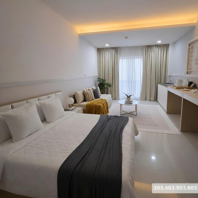 a bedroom with a large bed and a living room at 1001 Stars Hotel in Ho Chi Minh City