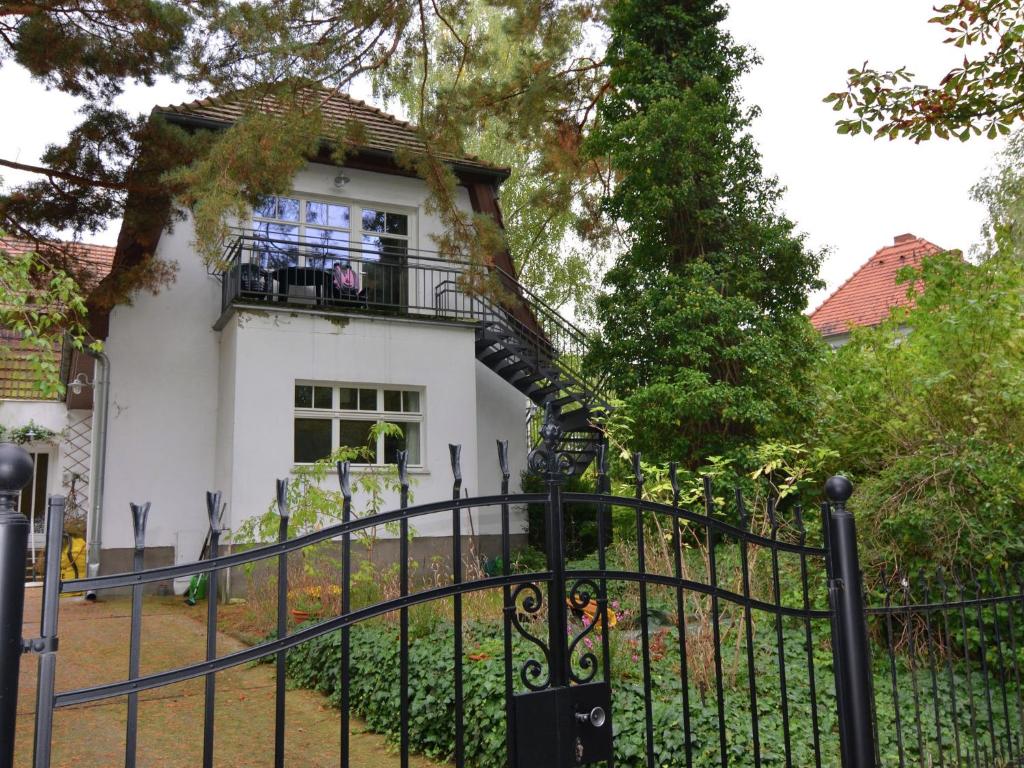 Uma casa branca com uma cerca preta à frente. em Striking Apartment near Lake in Wannsee em Berlim