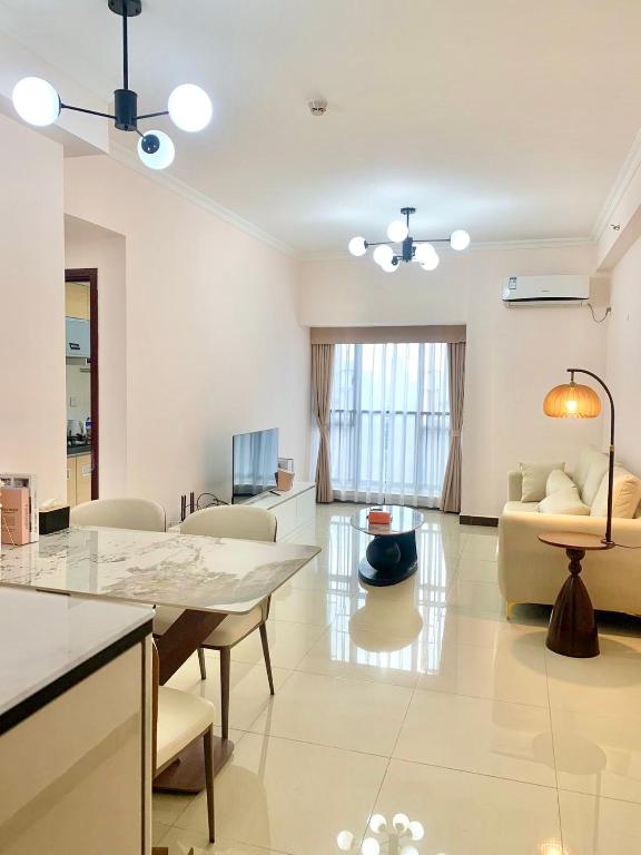 a living room with a table and a couch at Guangzhou Phantom Oasis Apartments - Canton Fair Exhibition Area in Guangzhou