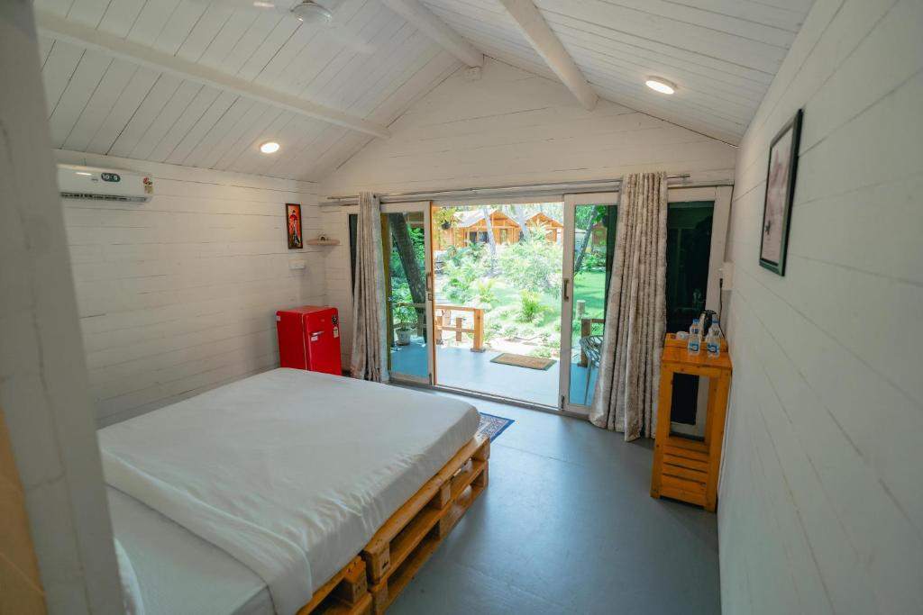 a small bedroom with a bed and a window at The Pearl Beach Resort in Canacona
