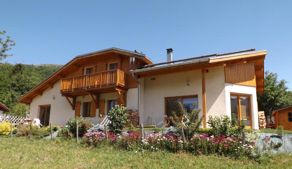 a house with a balcony and flowers in front of it at Le chalet d'Heidi in Bourg-Saint-Maurice