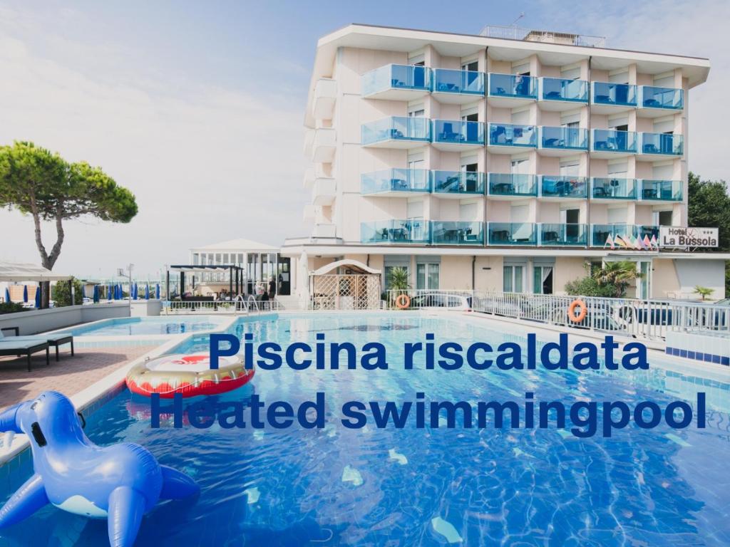 a hotel swimming pool in front of a hotel at Hotel La Bussola in Lido di Jesolo