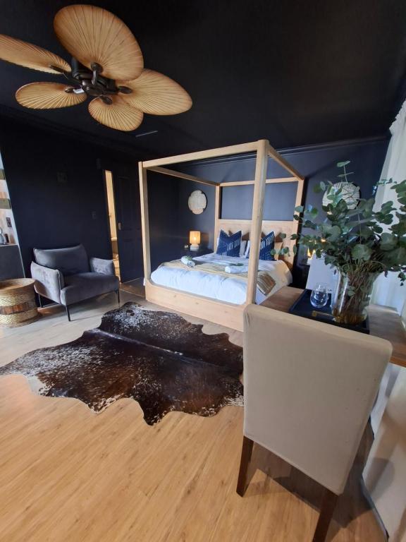 a bedroom with a bed and a ceiling fan at Forest Nature Spa in Plettenberg Bay