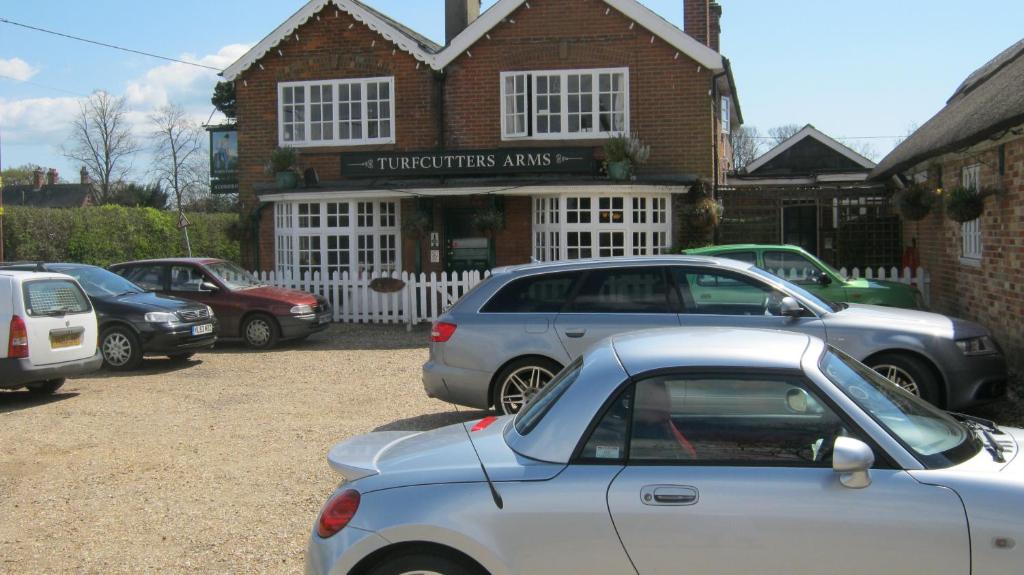 un grupo de coches estacionados frente a un edificio en Turfcutters Arms, en Boldre