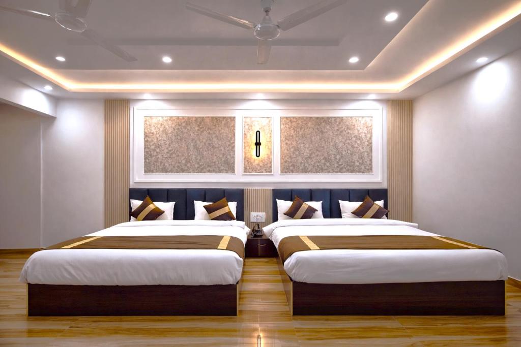 a bedroom with two beds and a window at Celestial Inn in Prayagraj