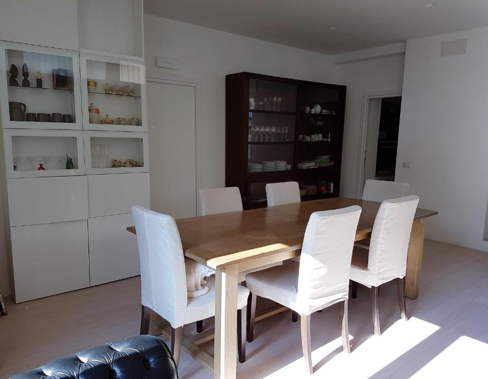 a dining room with a wooden table and white chairs at B&B Rosa Blu in Como