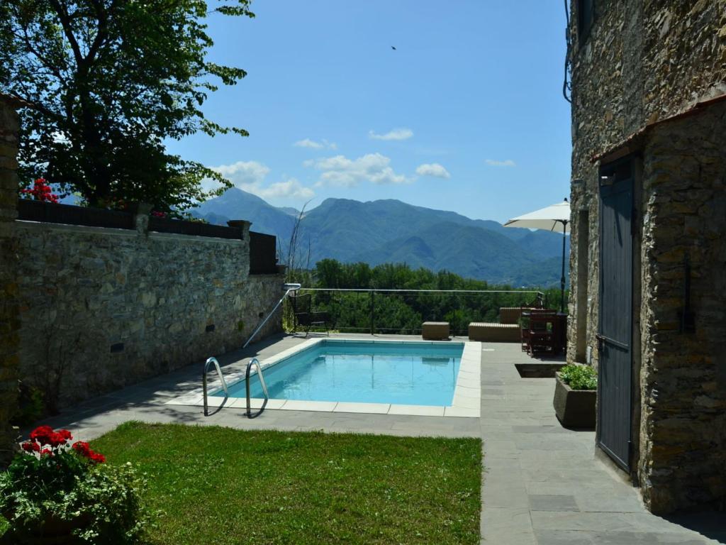 una piscina en un patio con montañas al fondo en Belvilla by OYO Casa Mazzola, en Fivizzano