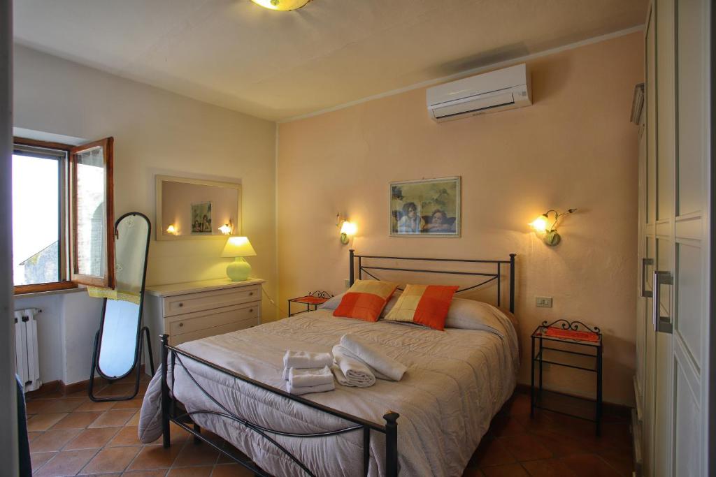 a bedroom with a large bed with orange pillows at La Torre Nomipesciolini in San Gimignano